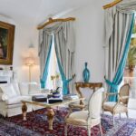 Sal&atilde;o cl&aacute;ssico com lareira de m&aacute;rmore e cortinas elegantes em hotel de luxo, refer&ecirc;ncia de onde ficar em amalfi com estilo hist&oacute;rico.
