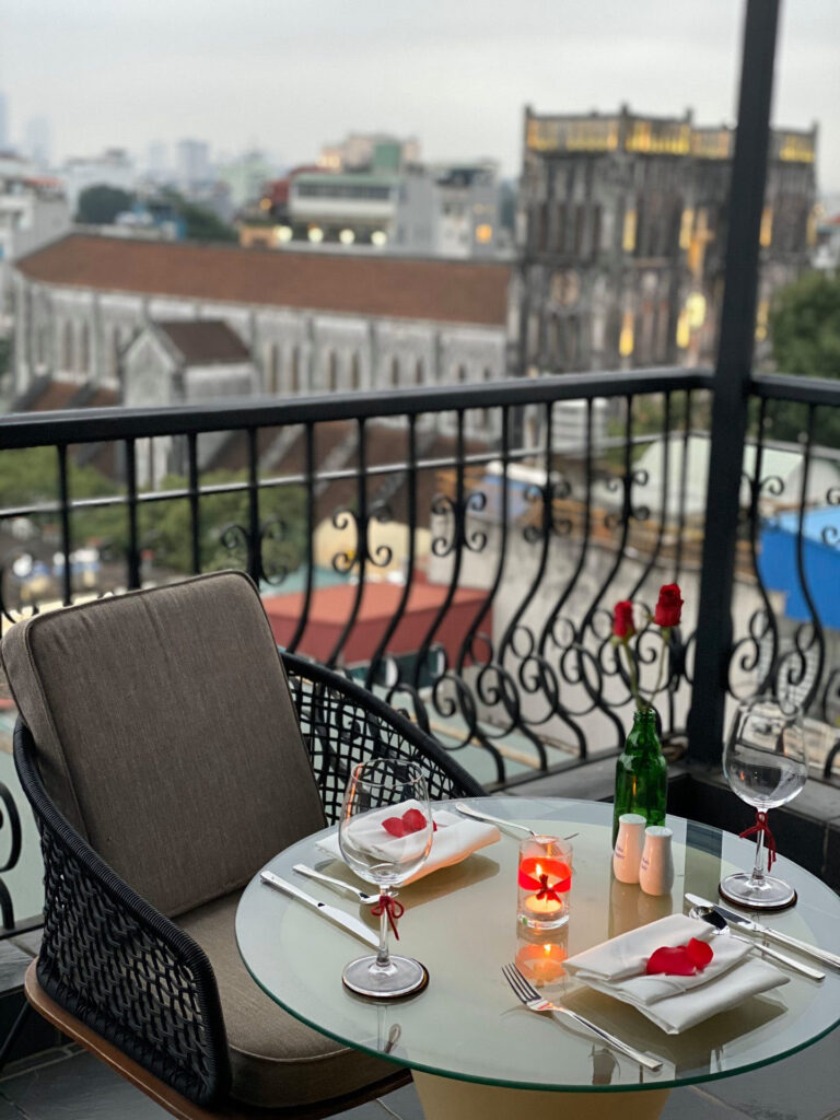Jantar romântico no terraço com vista para a Catedral de Hanói, uma experiência exclusiva oferecida pelos melhores hoteis em hanoi.