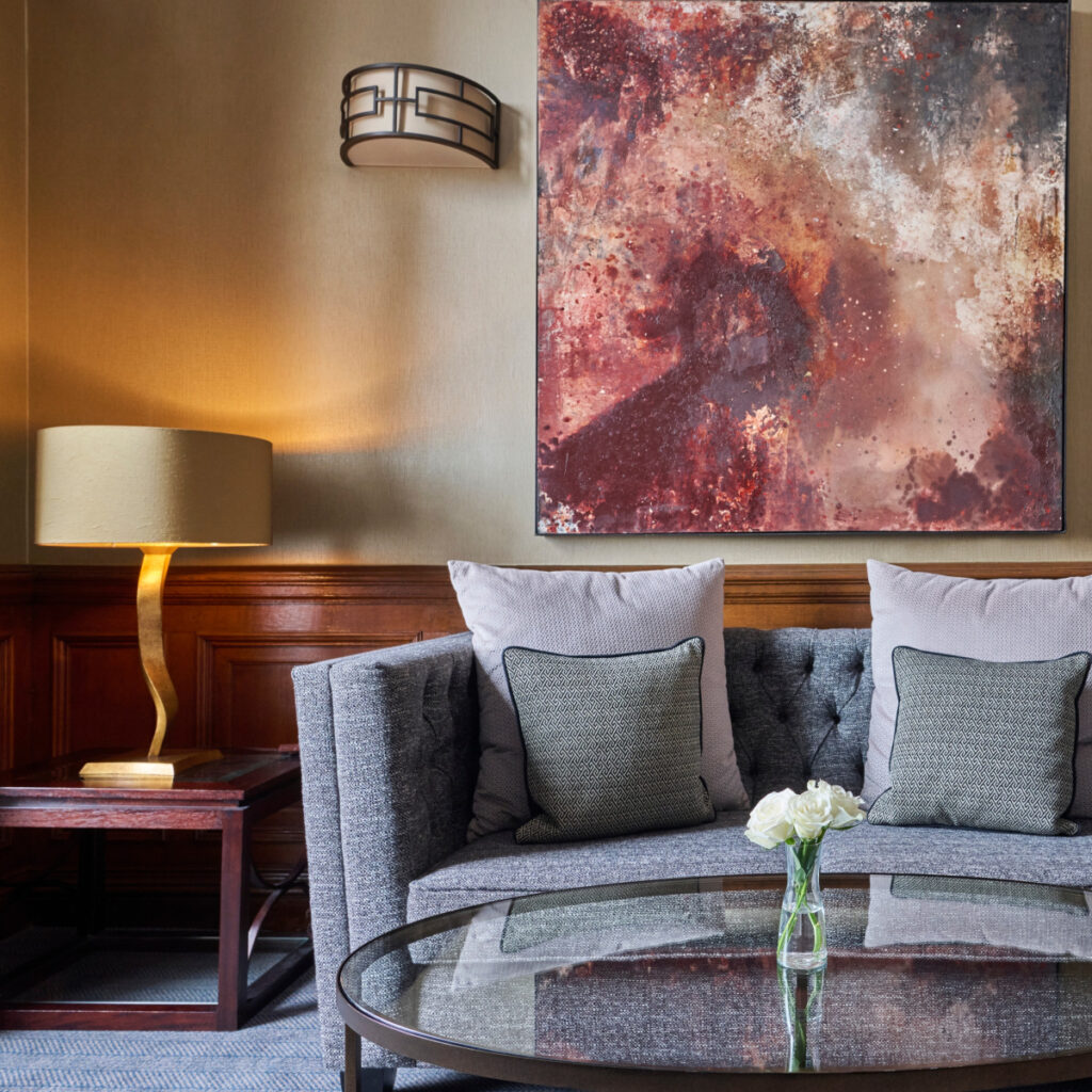 Canto de leitura com sofá cinza e luminária dourada em apart hotel em edimburgo.