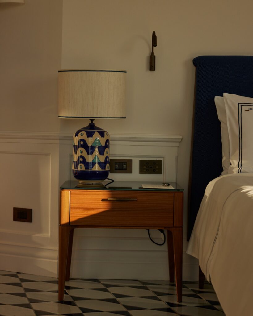 Detalhe de quarto com abajur artesanal e mesa de cabeceira de design em hotel onde ficar em amalfi.
