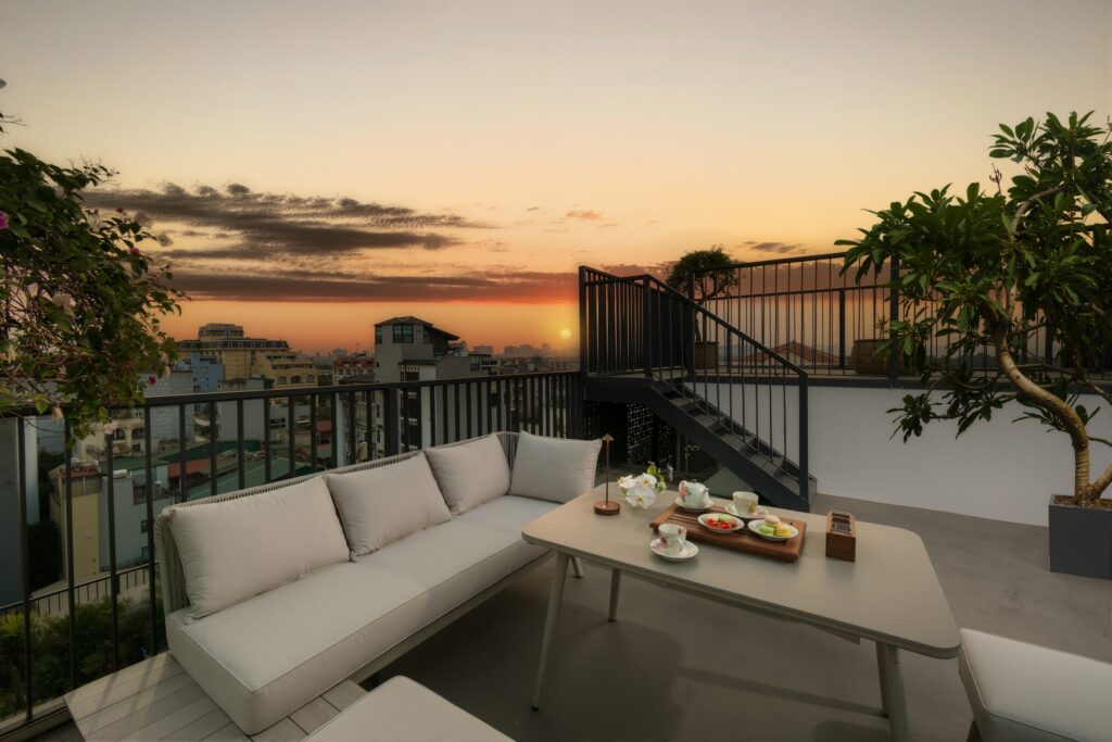 Lounge externo no terraço durante o pôr do sol no Hotel de Lagom, destaque na curadoria de hoteis em hanoi.