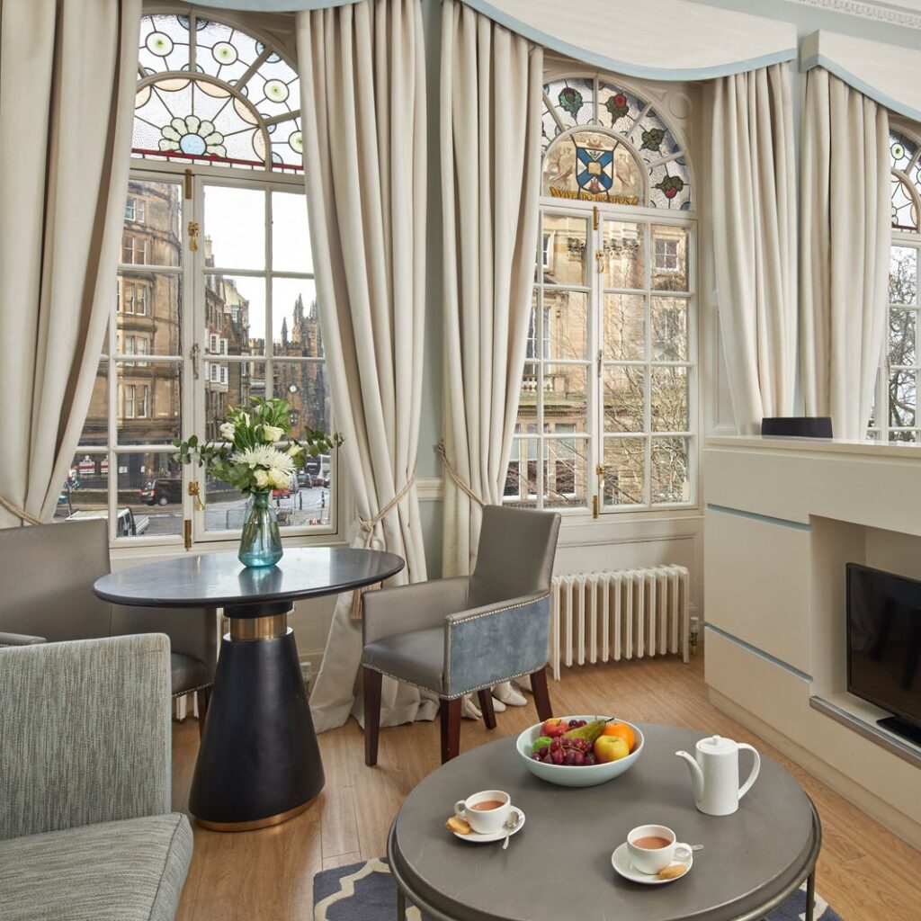 Sala com vitrais históricos e móveis modernos em apart hotel em edimburgo.