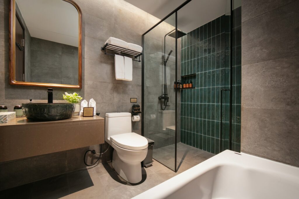 Banheiro moderno com metais pretos e revestimento verde esmeralda no Hotel de Lagom, referência de hoteis em hanoi.