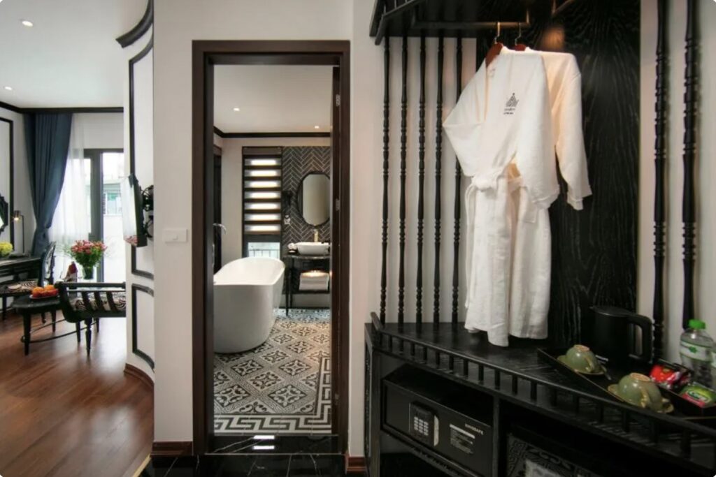 Closet funcional com design elegante e roupões de luxo no Le Chateau Hotel & Spa, destaque em hoteis em hanoi.