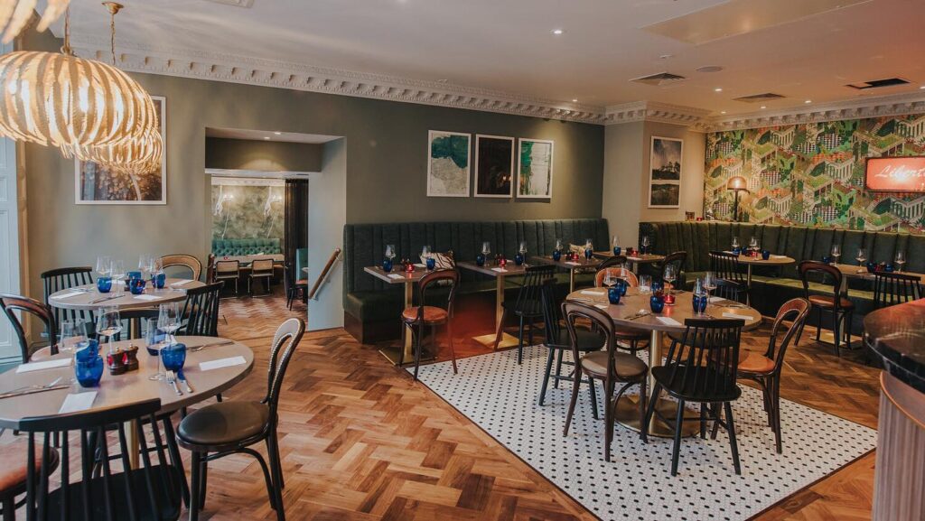 Restaurante sofisticado com decoração verde e piso de madeira em apart hotel em edimburgo.