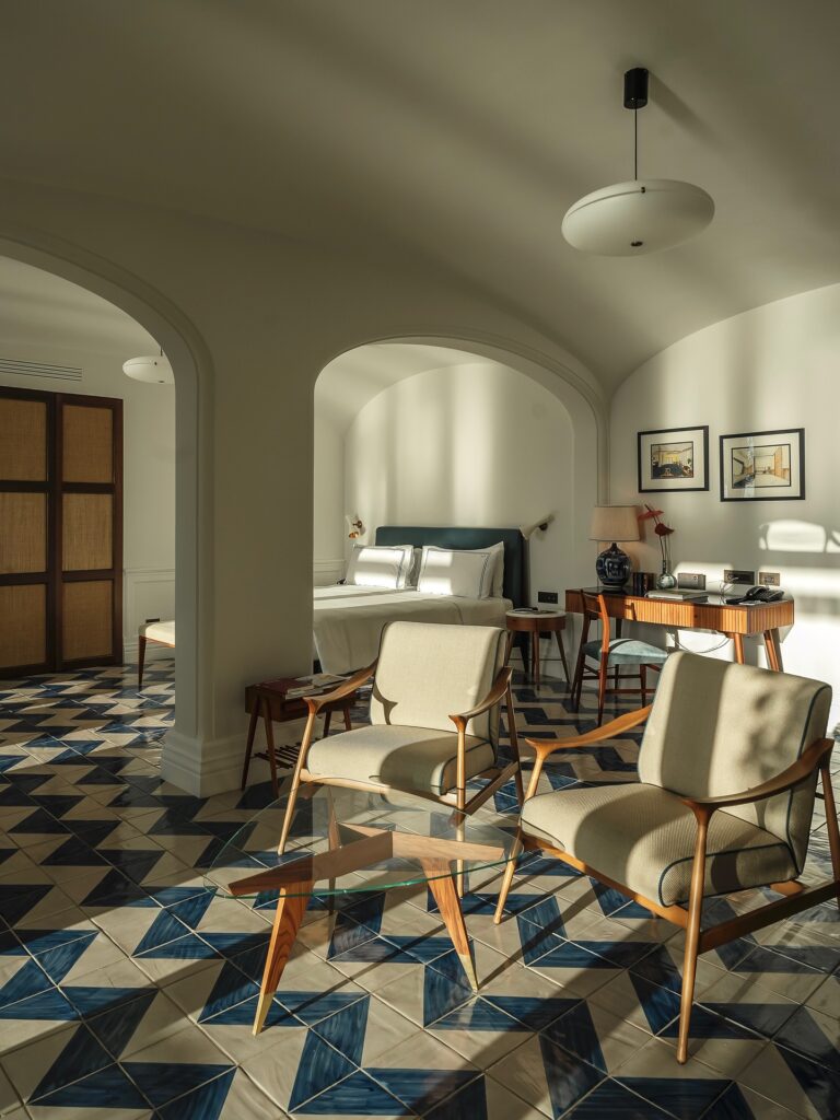 Sala de estar em suíte de luxo com poltronas de design e piso decorado em hotel onde ficar em amalfi.
