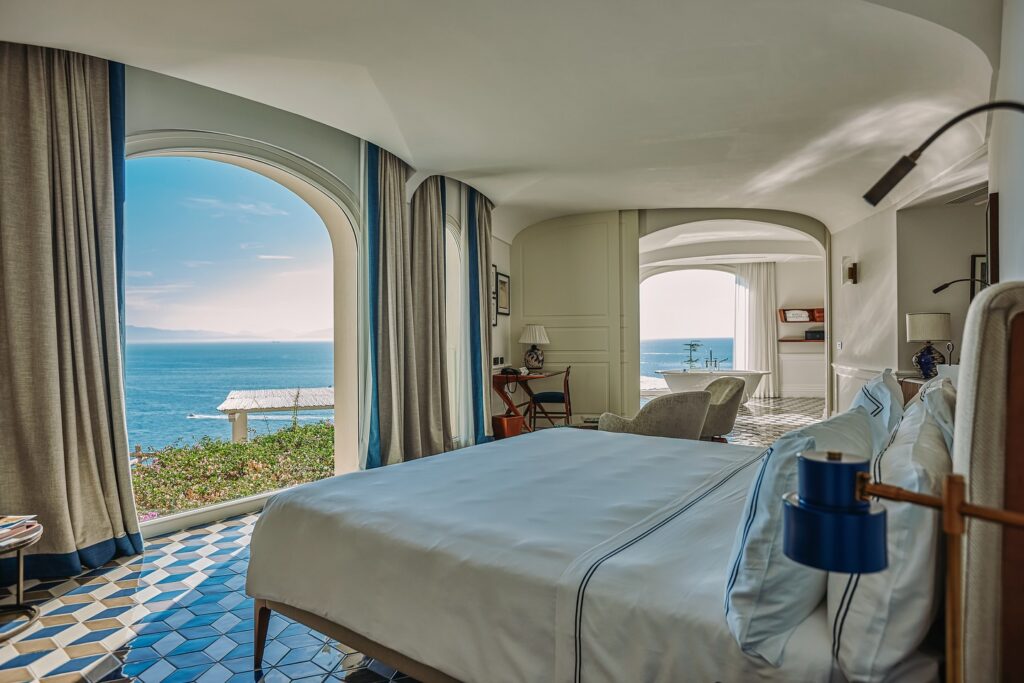 Quarto de luxo com vista panorâmica do oceano e piso cerâmico artístico em hotel onde ficar em amalfi.