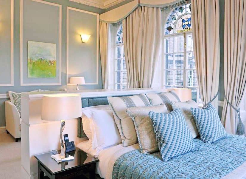 Quarto luxuoso com vitrais históricos e enxoval azul em apart hotel em edimburgo.