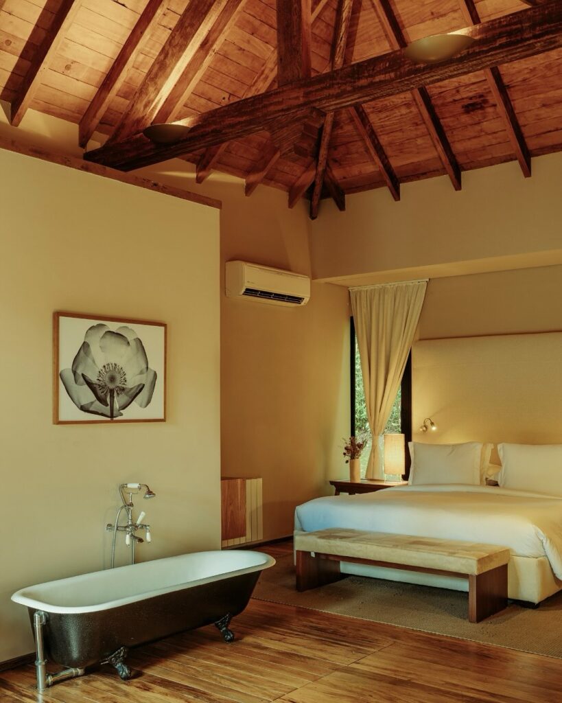 Suíte luxuosa com banheira e teto de madeira, um verdadeiro refúgio para a páscoa com foco em bem-estar.