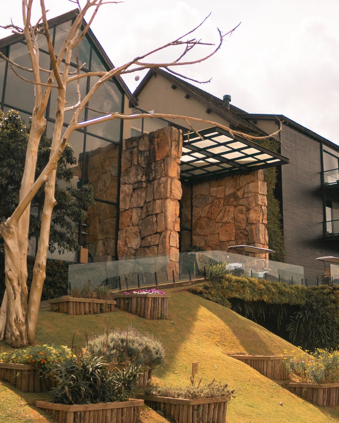 Fachada de pedra e vidro integrada à natureza, perfeita para quem busca um refúgio para a páscoa com arquitetura autoral.