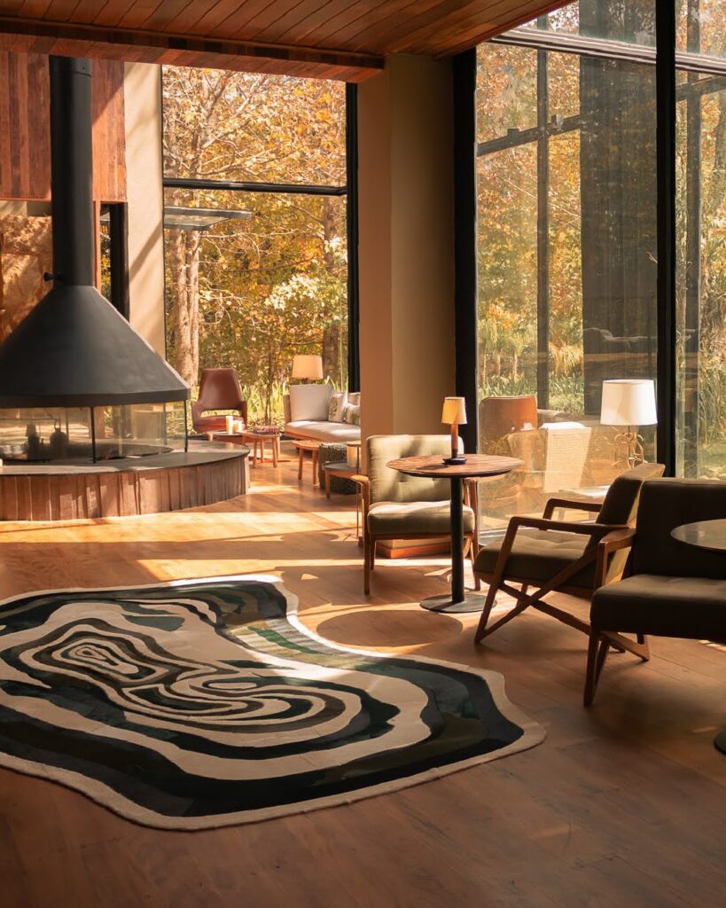 Lounge com lareira e grandes janelas, oferecendo um ambiente acolhedor como refúgio para a páscoa.