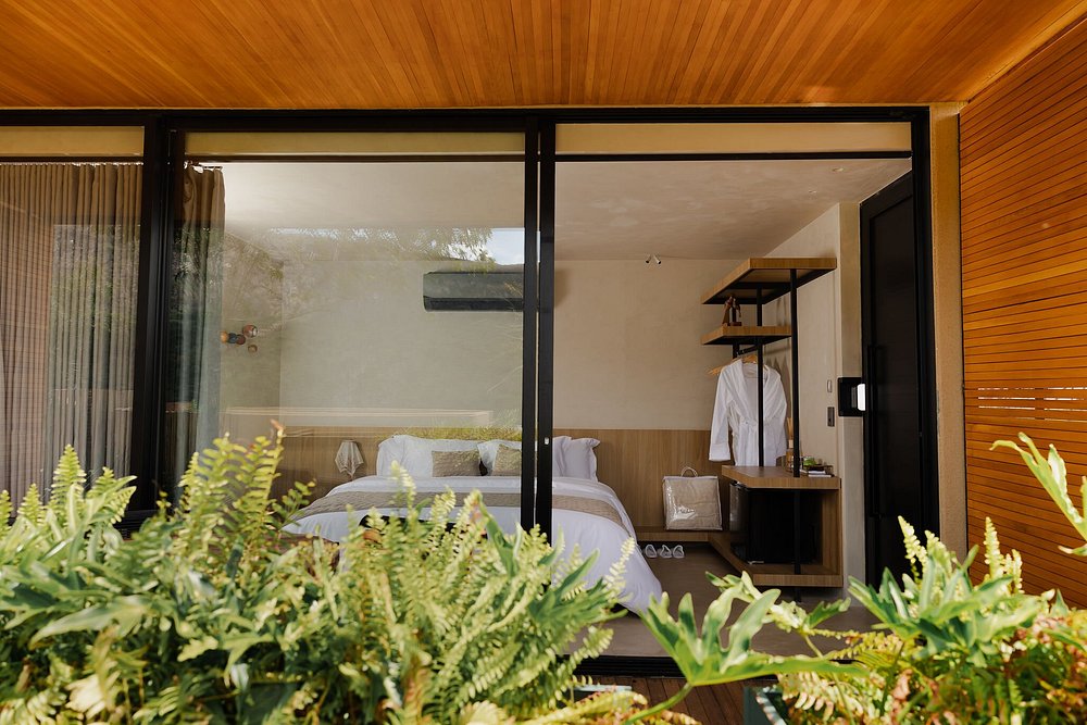 Suíte de hotel integrada à natureza com forro de madeira, perfeita para um refúgio para a páscoa.