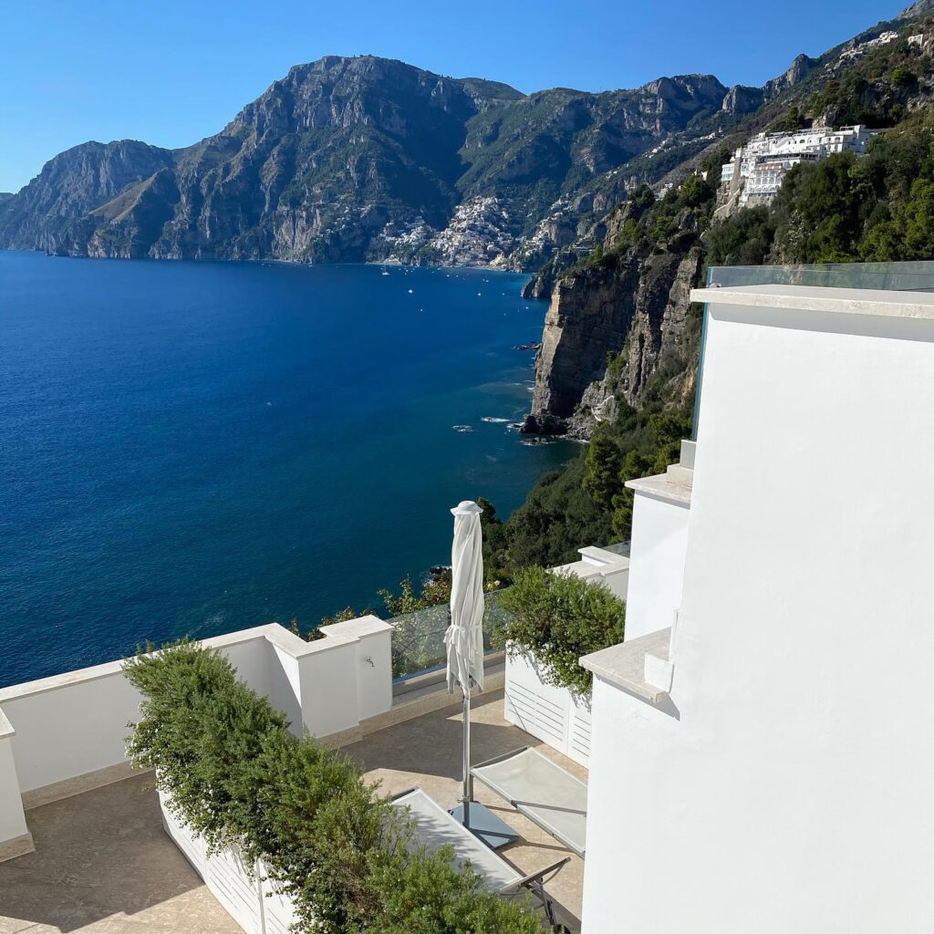Terraço com vista panorâmica das falésias, uma opção luxuosa de onde ficar em amalfi para apreciar o mar.