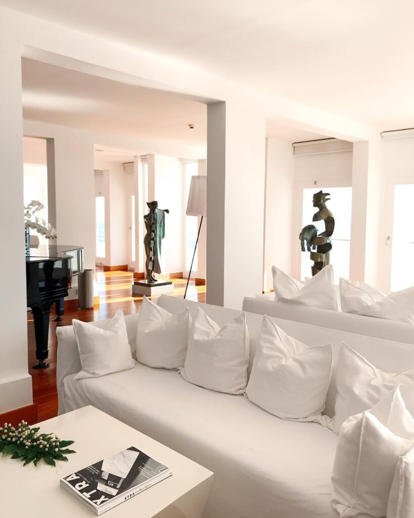 Lobby minimalista com sofás brancos e esculturas de arte, referência de onde ficar em amalfi com design sofisticado.