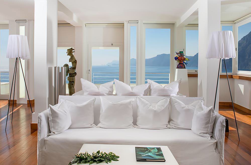 Sala decorada com arte e móveis de design, uma sugestão elegante de onde ficar na costa amalfitana.