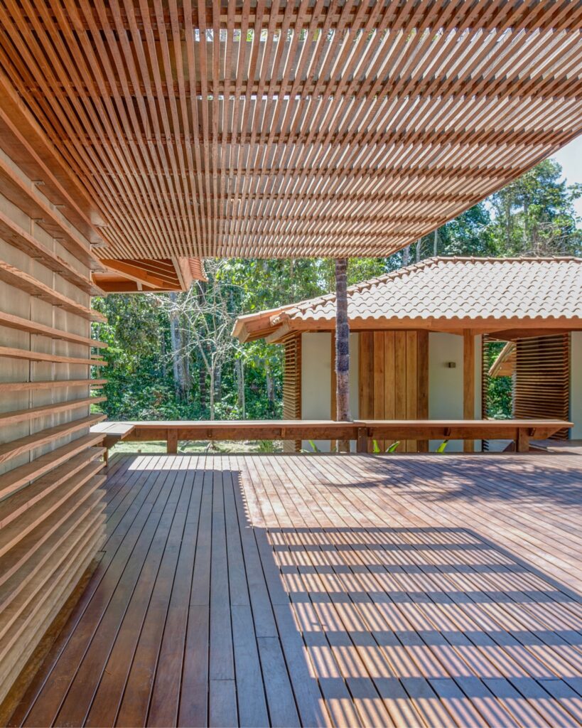 Deck de madeira com pergolado, ideal para relaxar em um refúgio para a páscoa imerso na selva.