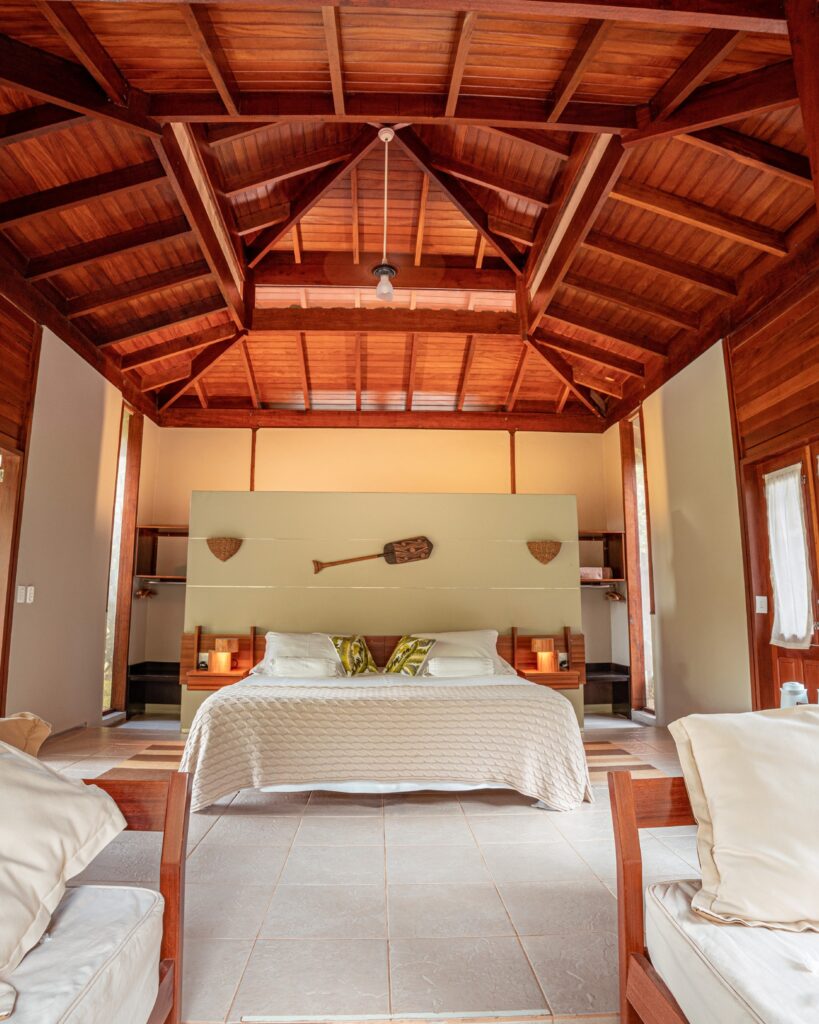 Quarto espaçoso com teto de madeira, um refúgio para a páscoa focado no descanso e silêncio da floresta.