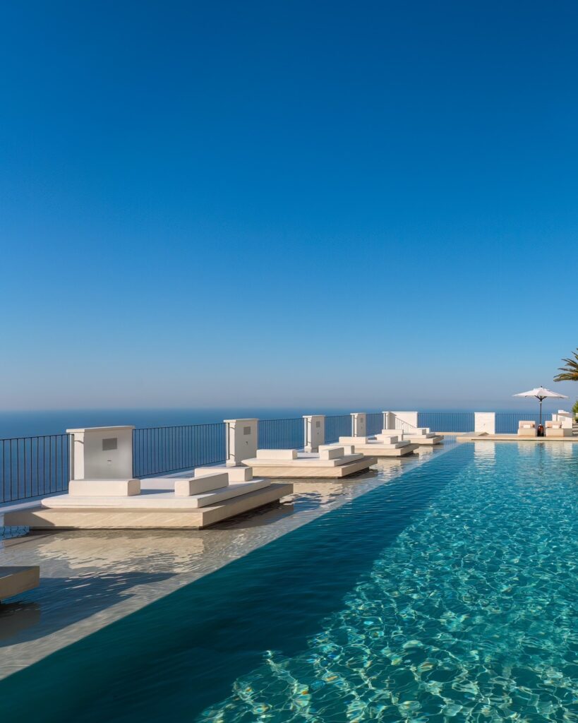 Piscina de borda infinita com espreguiçadeiras flutuantes no Furore Grand Hotel, dica premium de onde ficar em amalfi.