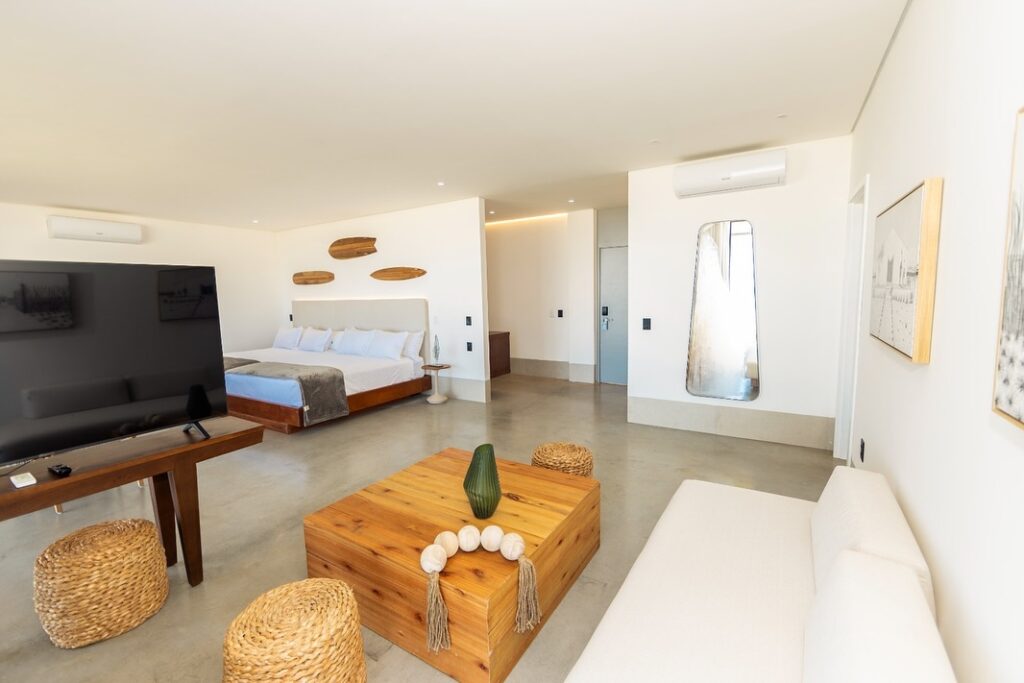 Suíte luxuosa com design natural e detalhes em madeira, uma das melhores opções de hoteis em são miguel do gostoso.