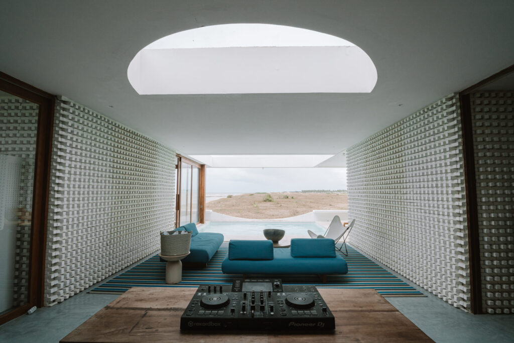 Espaço social com sofás azuis e iluminação natural por clarabóia, ambiente moderno de hoteis em são miguel do gostoso.