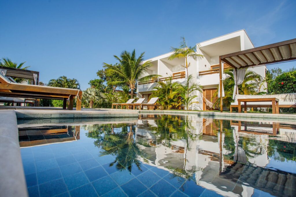 Piscina com reflexo da arquitetura minimalista da Pousada Portofino, opção sofisticada de hoteis em são miguel do gostoso para relaxar.