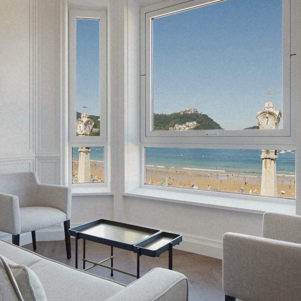 Área de estar no Hotel Villa Favorita San Sebastian com poltronas cinzas e vista para a praia de La Concha.