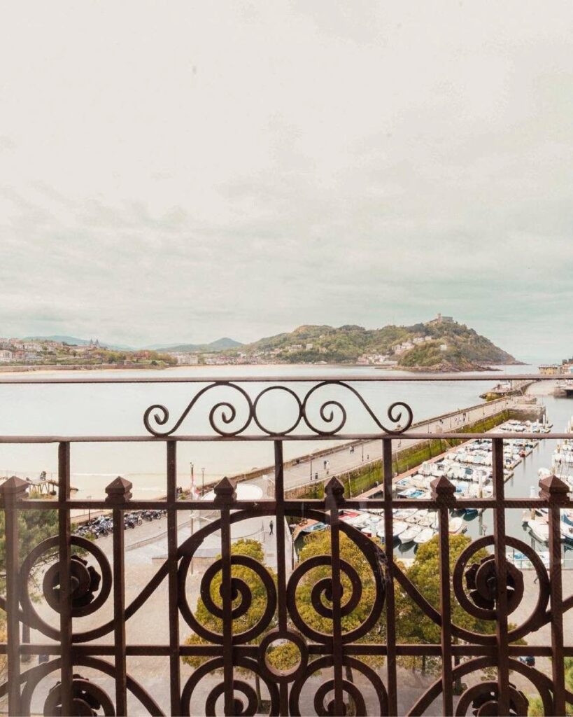 Vista da Baía de La Concha a partir da sacada do Lasala Plaza Hotel San Sebastian, emoldurada por guarda-corpo de ferro artístico.