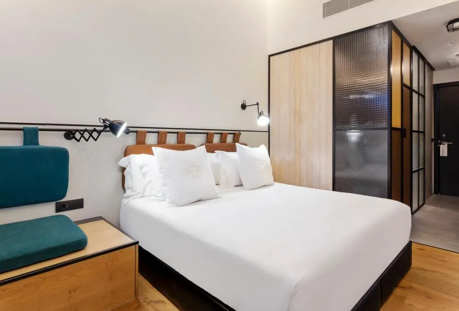 Cabeceira de couro e divisória de vidro canelado em quarto moderno no One Shot Tabakalera House San Sebastian.