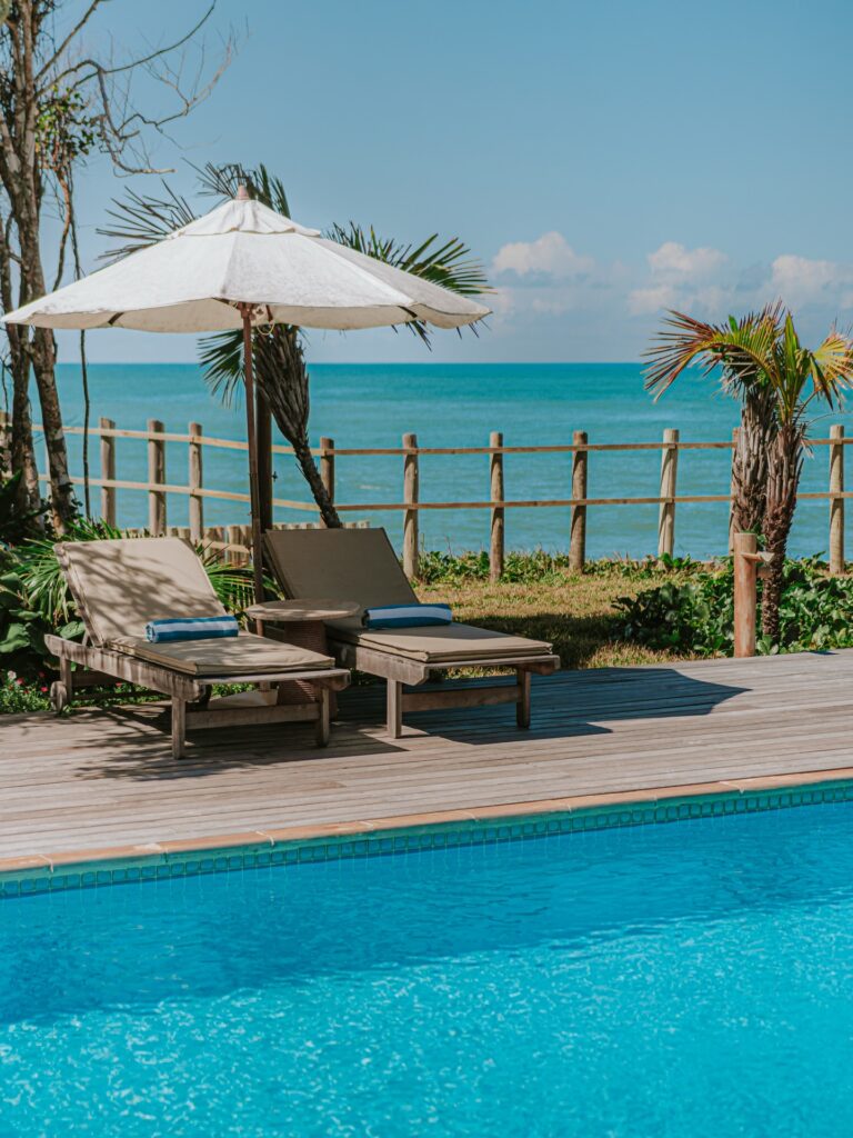 Piscina com deck de madeira e vista para o mar na Pousada Tutabel, um verdadeiro refúgio para páscoa com design pé na areia.