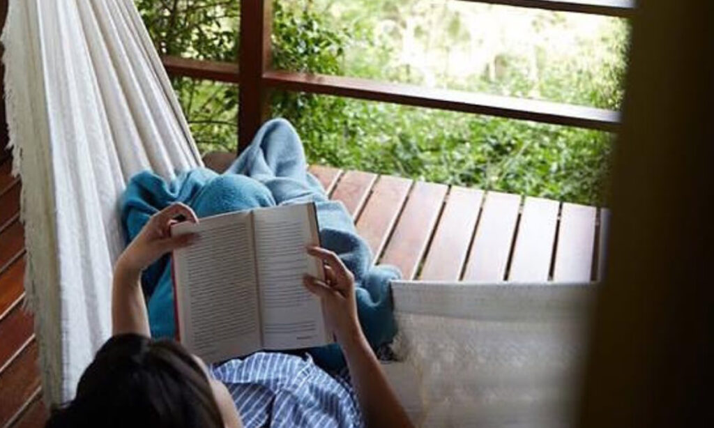mulher lendo na rede na pousada do cedro