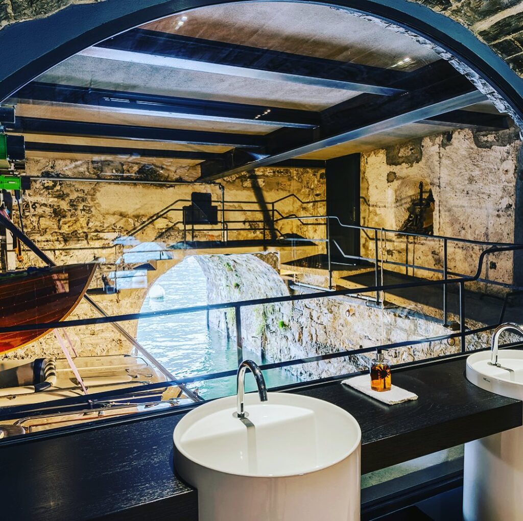 Boathouse histórica com arco de pedra e lavatórios de design modernos no Villa Làrio, hotéis com arquitetura no lago di Como.