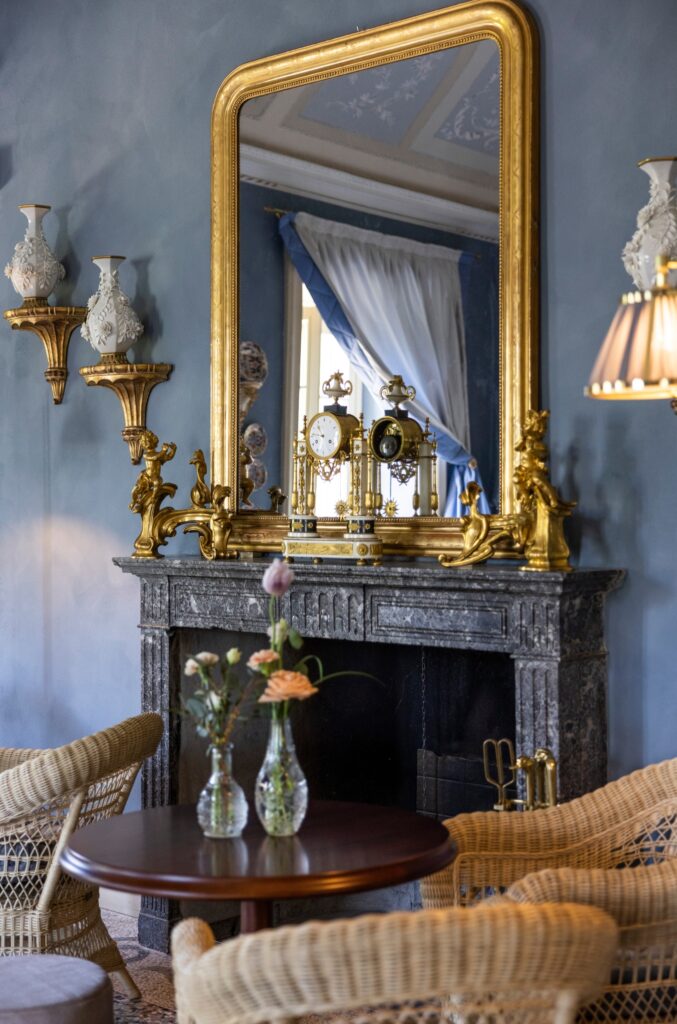Lareira com espelho dourado e castiçais barrocos em sala de estar do Passalacqua, hotel de ultra-luxo entre os hotéis no lago di Como.