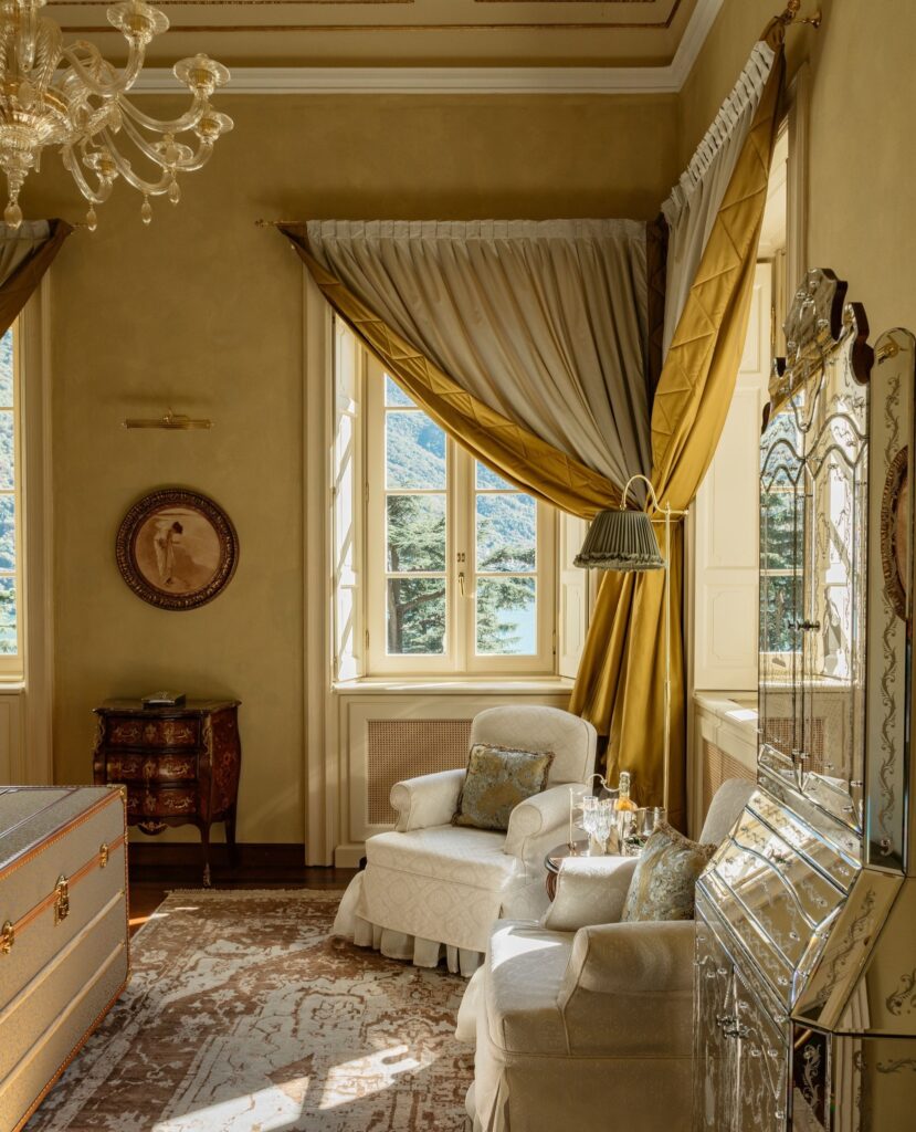 Sala com lustre de Murano, espelho veneziano e baú vintage, suíte histórica nos hotéis de luxo do lago di Como.
