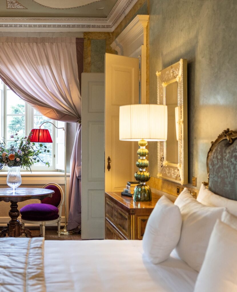 Suíte com paredes em velatura azul-esverdeado e luminária de Murano, quarto histórico nos hotéis no lago di Como do Passalacqua.