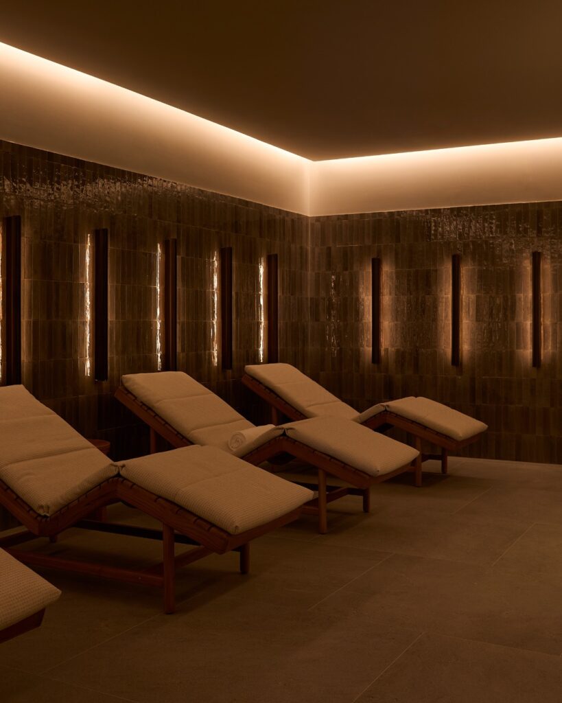 Sala de relaxamento do spa com azulejo artesanal escuro e iluminação indireta no Longevity Spa do The Lake Como EDITION.