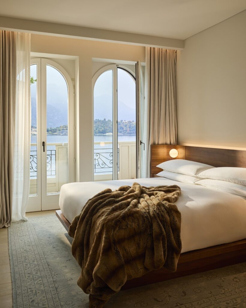 Quarto com portas arqueadas históricas e cama de nogueira assinada por Neri & Hu no The Lake Como EDITION, hotel de design no lago di Como.