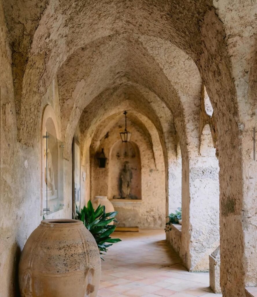 Corredor arqueado de pedra com design histórico na Villa Cimbrone, dica de onde ficar em amalfi.