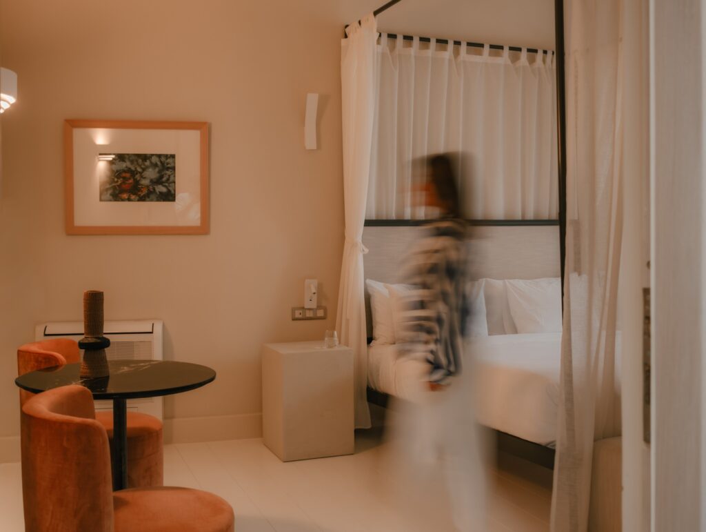 Quarto elegante com cama de dossel e tons terra no Azade Chania, um dos melhores hoteis da ilha de creta.