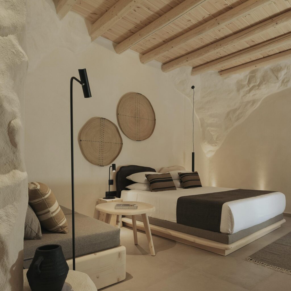 Suíte luxuosa com design orgânico e paredes texturizadas, um dos melhores hotéis da ilha de Creta.