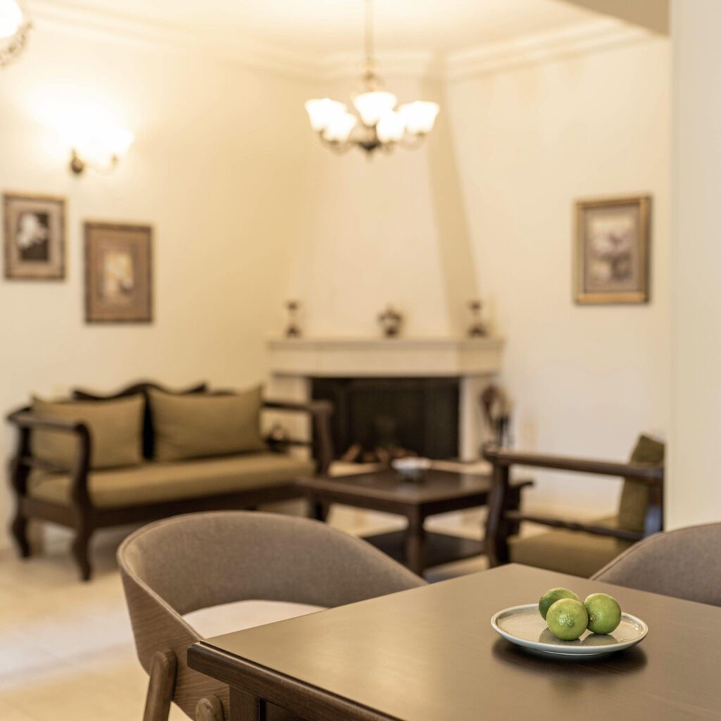 Sala de estar elegante com lareira e tons neutros, representante dos melhores hotéis da ilha de Creta.