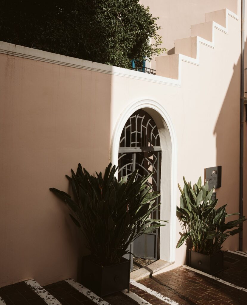 Pátio externo com arquitetura clássica e portal em arco no Casa Delfino, um dos melhores hoteis da ilha de creta.