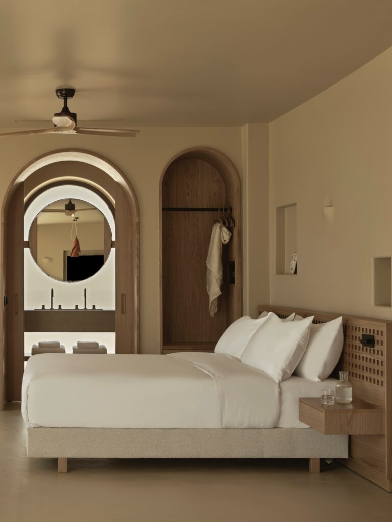 Quarto de hotel minimalista com arcos e madeira clara no Tella Thera, destaque entre melhores hoteis da ilha de creta.