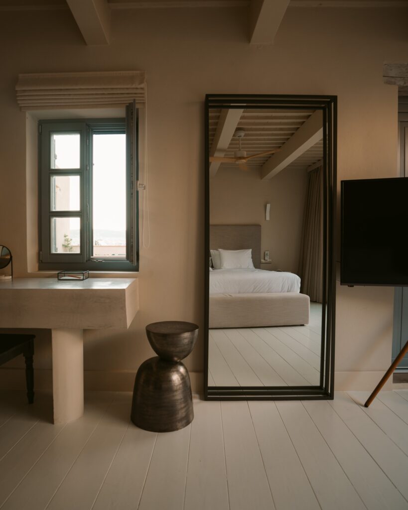 Design de interiores com espelho grande e vigas expostas, representando os melhores hoteis da ilha de creta.