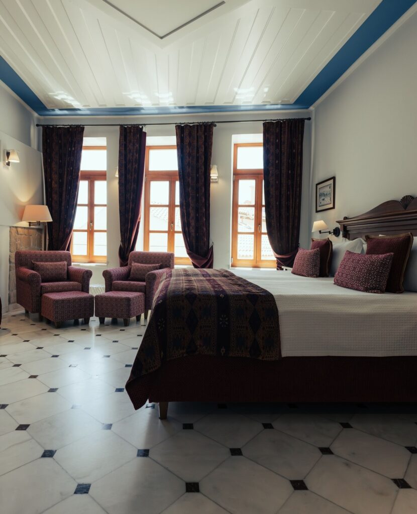 Quarto de luxo com decoração clássica e detalhes em bordô no Casa Delfino, um dos melhores hoteis da ilha de creta.