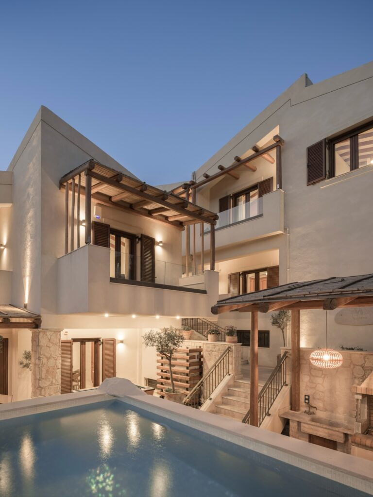 Arquitetura externa de hotel boutique com piscina ao entardecer, nos melhores hotéis da ilha de Creta.