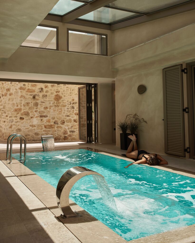 Piscina interna com teto de vidro e design em pedra, parte dos melhores hotéis da ilha de Creta.