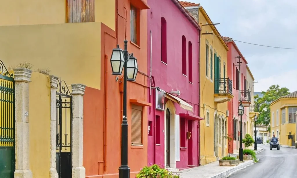 Fachadas coloridas de casas tradicionais na Ilha de Creta, com destaque para a paleta de cores vibrantes e arquitetura mediterrânea.