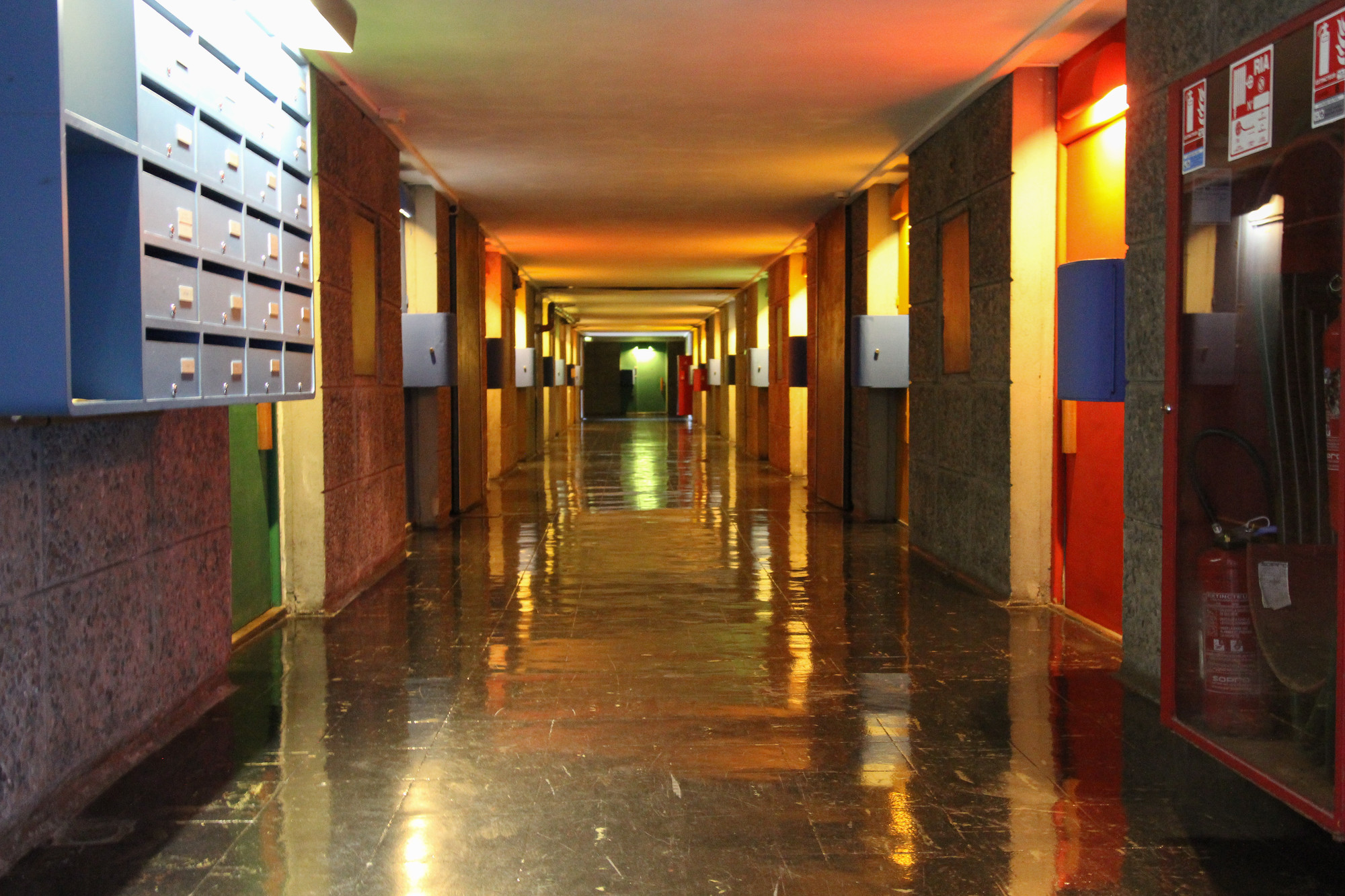 Corredor colorido da Cité Radieuse em Marselha, demonstrando o uso de cores primárias e concreto na arquitetura modernista de Le Corbusier.