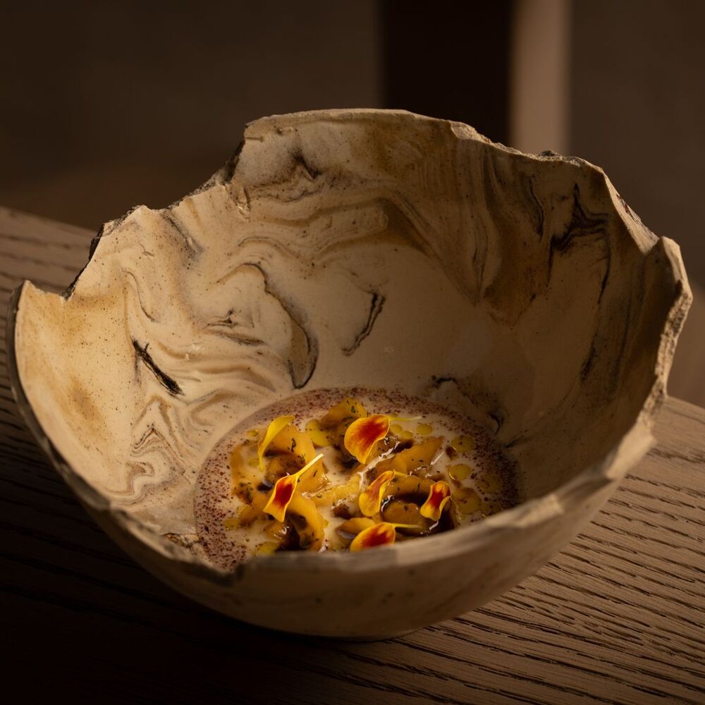 Sobremesa sofisticada servida em bowl de cerâmica artística no restaurante nomos ante.