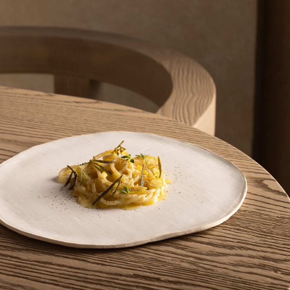 Massa artesanal servida em prato de cerâmica orgânica no restaurante nomos ante.